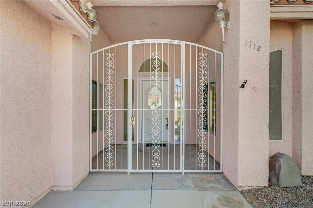 Home entrance with a white ornamental security gate and covered porch.