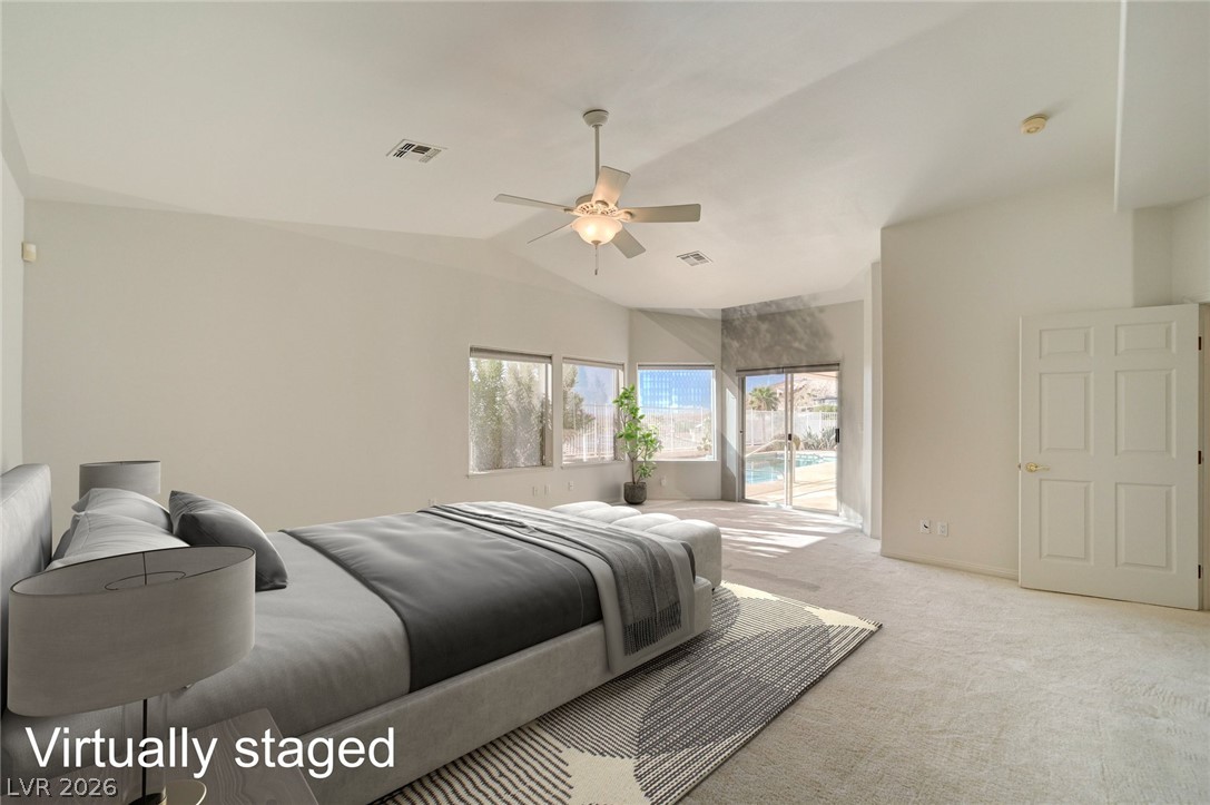 Virtually staged bedroom with a vaulted ceiling, ceiling fan, and sliding doors overlooking a pool.