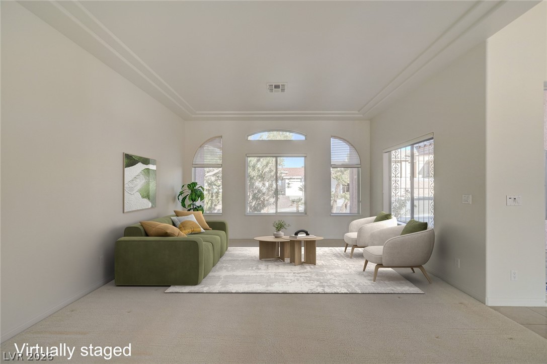 Virtually staged living room with a green sofa, light chairs, and large arched windows.