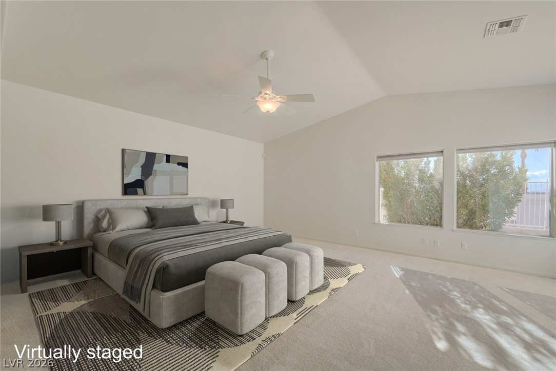 Virtually staged bedroom with a gray upholstered bed, three matching ottomans, and two windows.