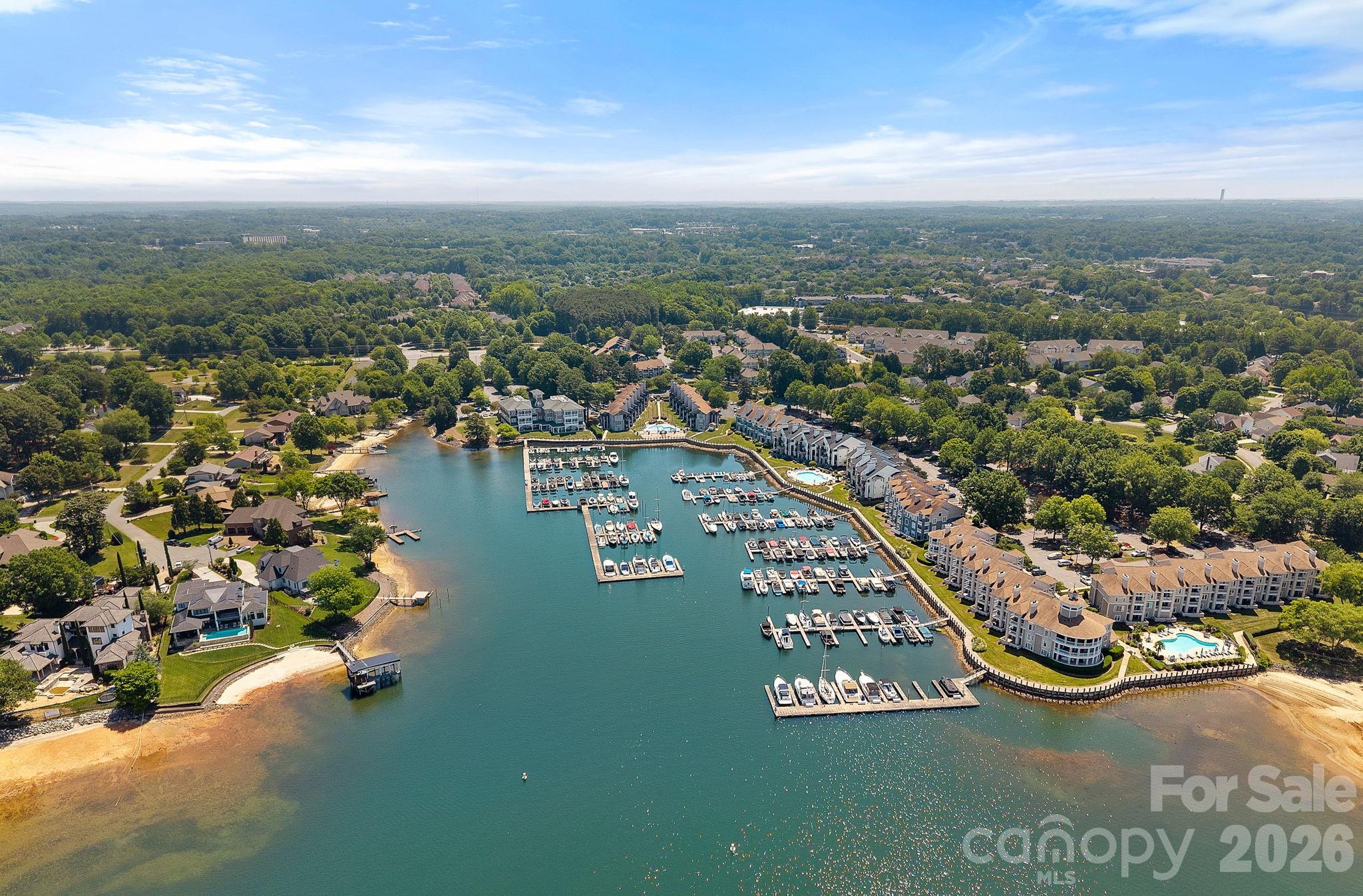 Aerial view of a Lake Norman marina, with boats docked beside waterfront homes and condominiums.