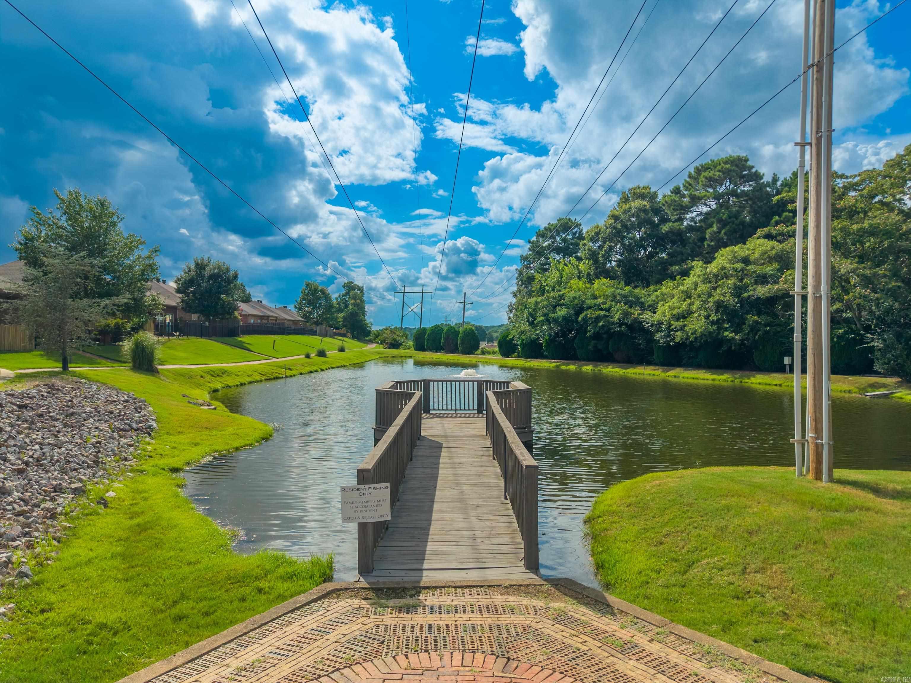 Fishing dock over a community pond, with a resident-only fishing sign and landscaped grassy banks.