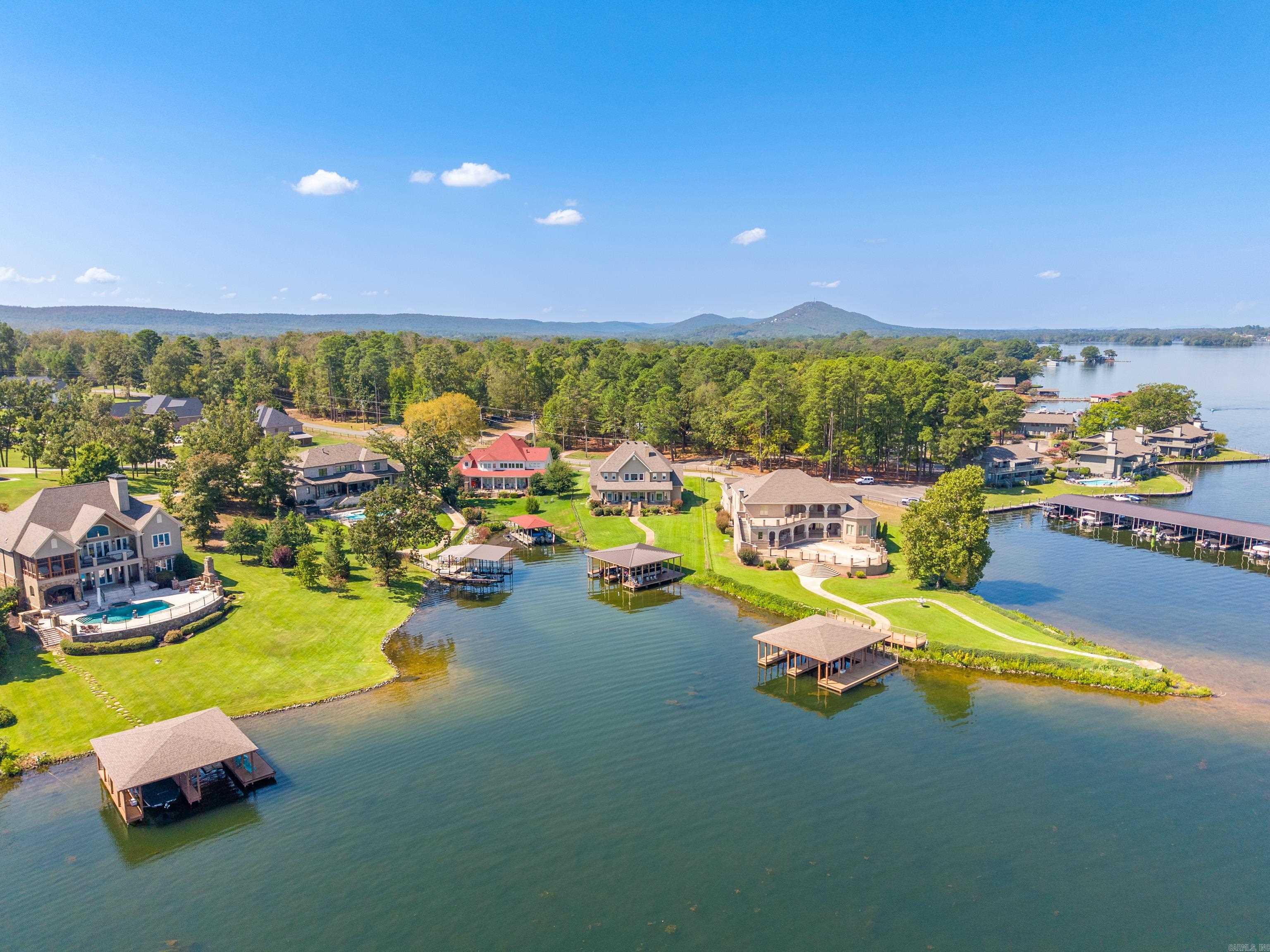 Aerial view of lakeside homes with private docks along a wooded shore.