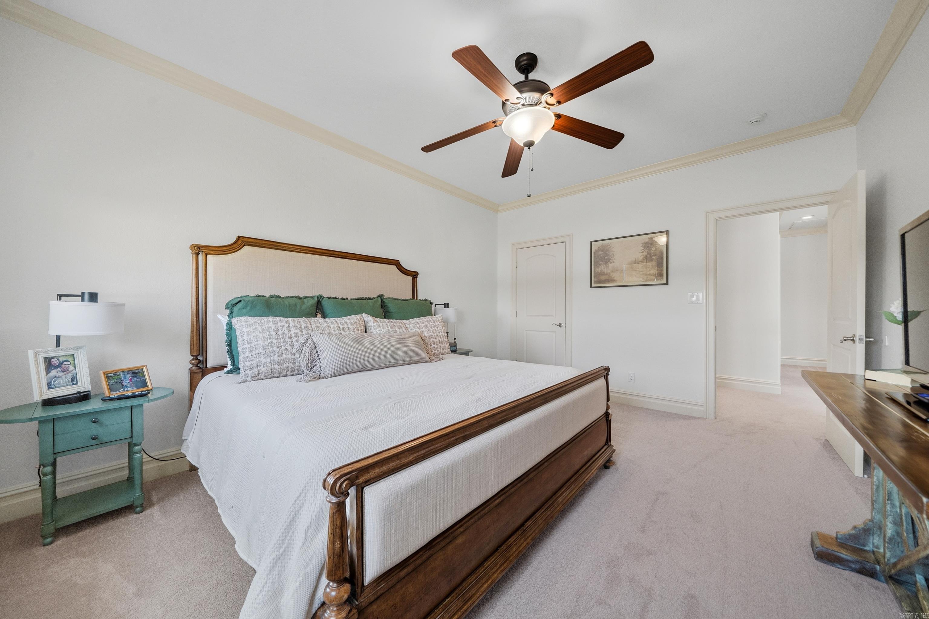 Bedroom with a dark wood bed, white bedding, green pillows, and a teal nightstand.