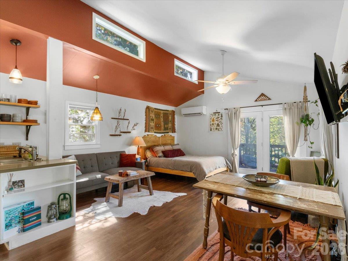 Open-plan bedroom and living area with a vaulted terracotta ceiling and glass doors to a balcony.