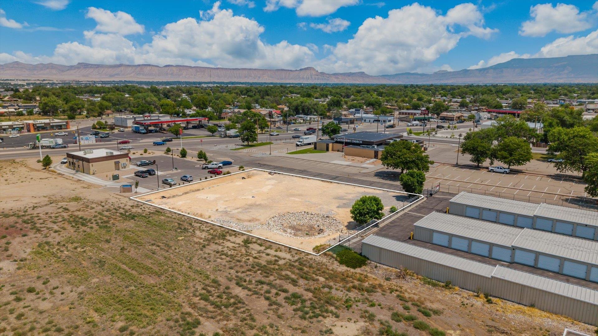 Vacant parcel outlined in Orchard Mesa, with nearby businesses and mesas in the distance.