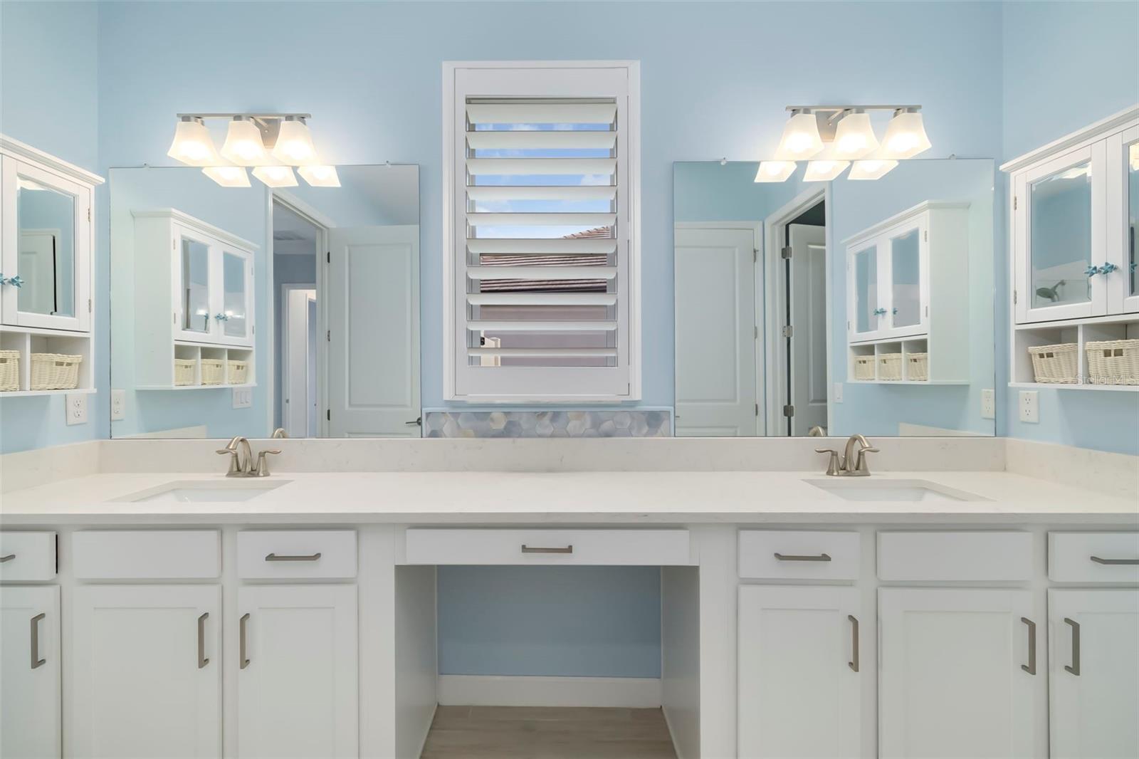 Bathroom with a wide double-sink vanity, mirrored cabinets, and a shuttered window.