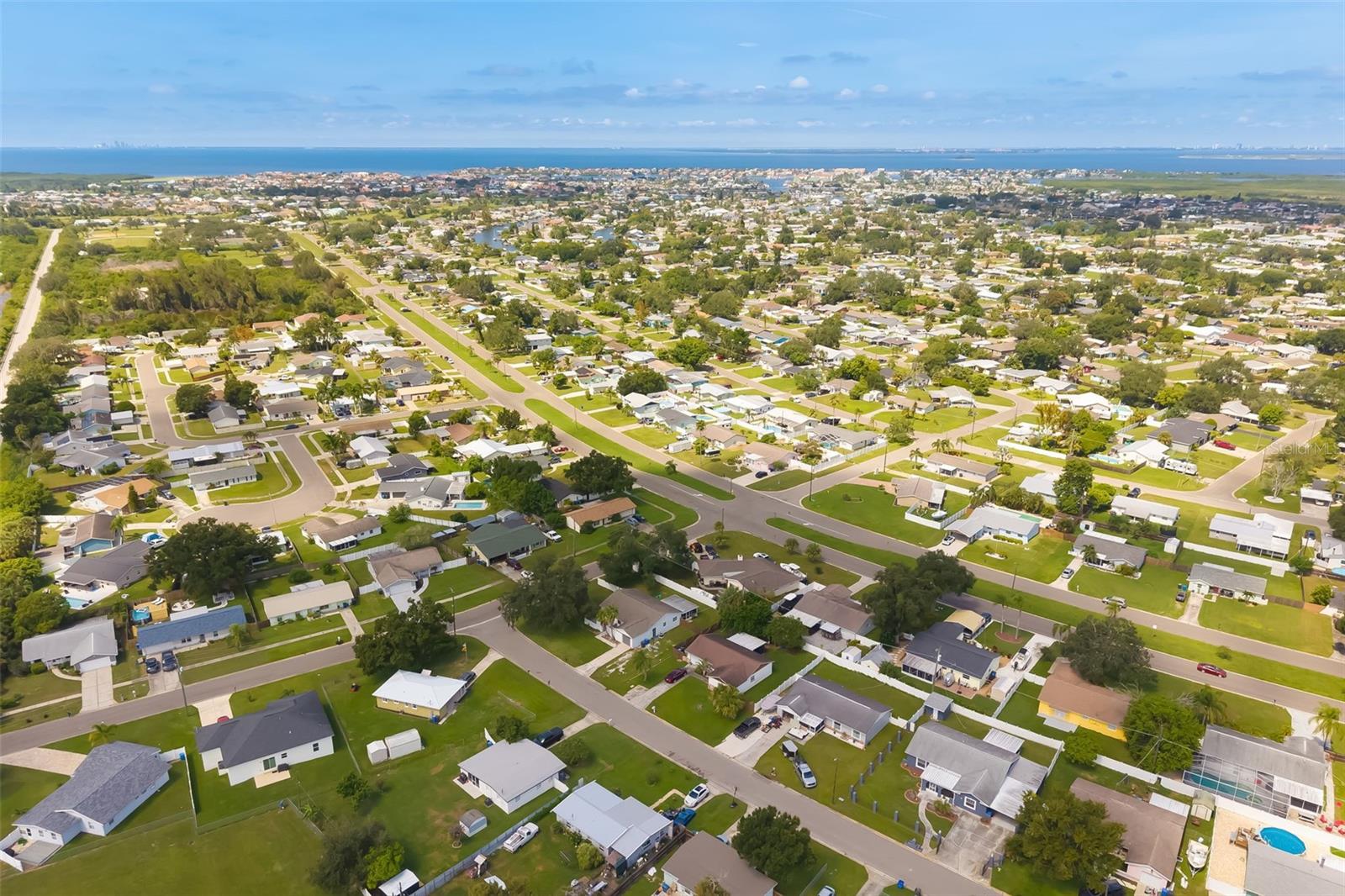 Aerial view of a coastal neighborhood, with homes and streets stretching toward the ocean.