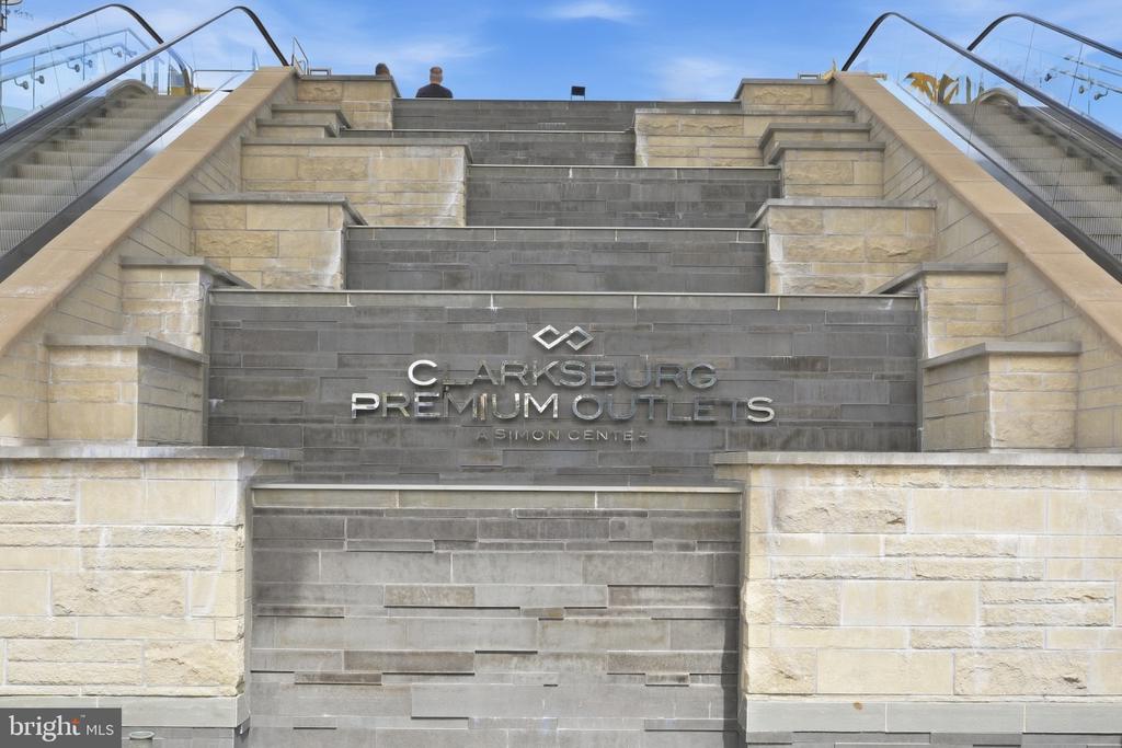 Clarksburg Premium Outlets entrance with stone steps and escalators.