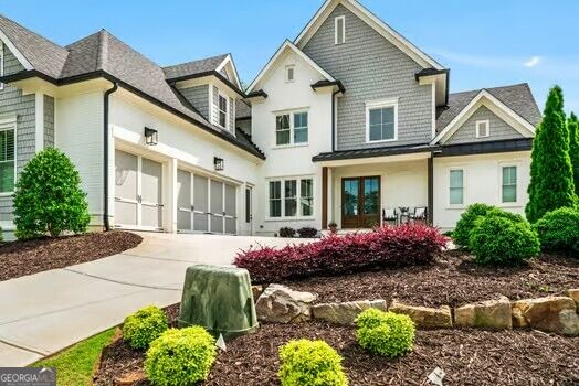 Two-story home with an attached garage, covered entry, and landscaped front yard.