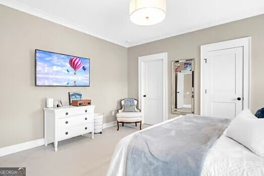 Bedroom with a white dresser, wall-mounted television, mirrored closet, and bed with gray bedding.