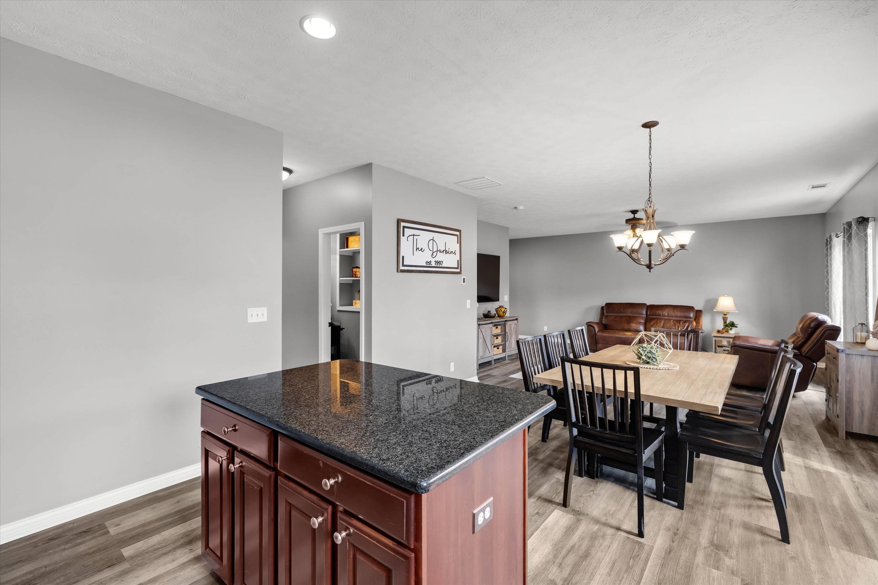 Kitchen island overlooks a dining table and adjoining living area.