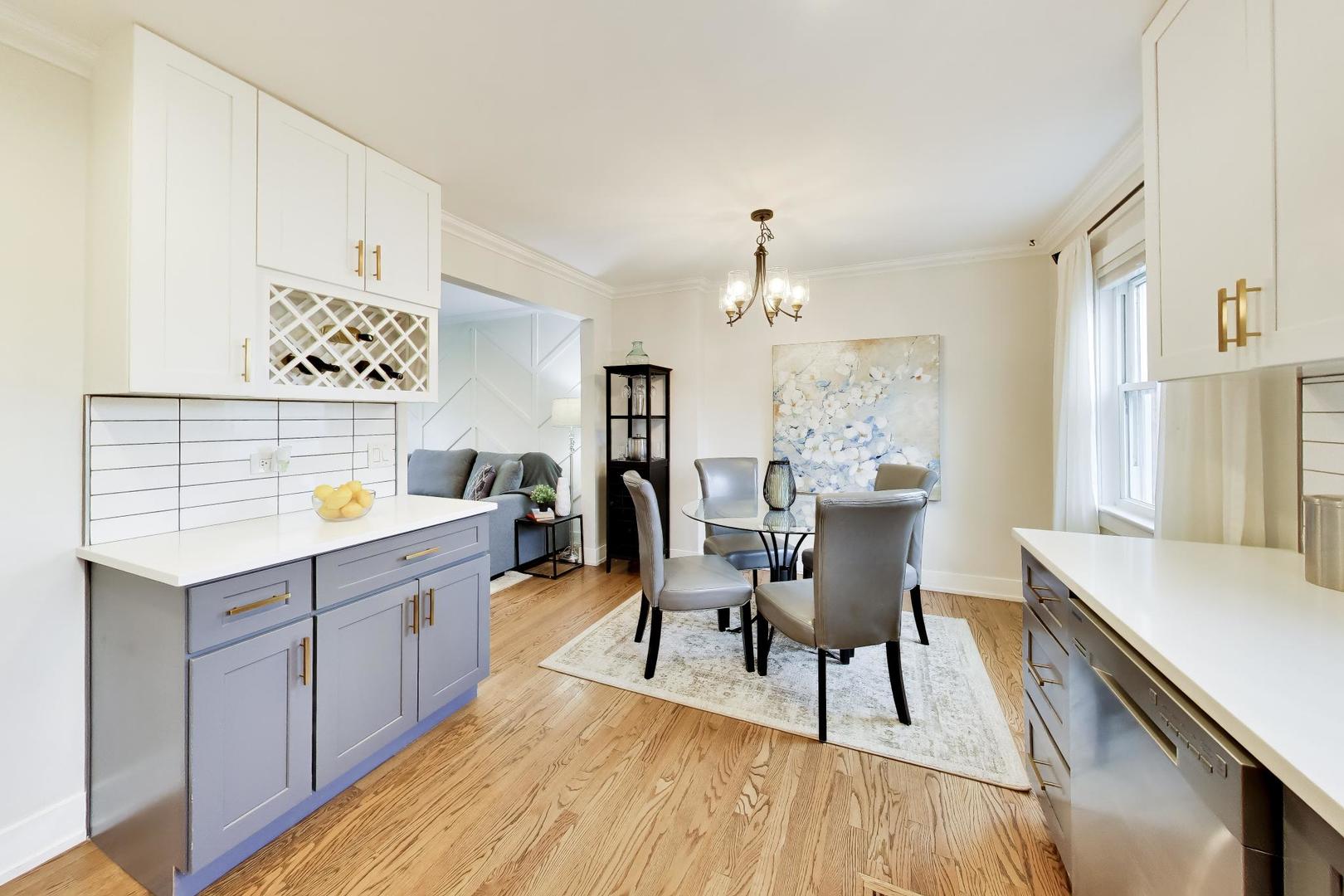 Kitchen and dining area with blue-gray cabinets, hardwood floors, and a round table.