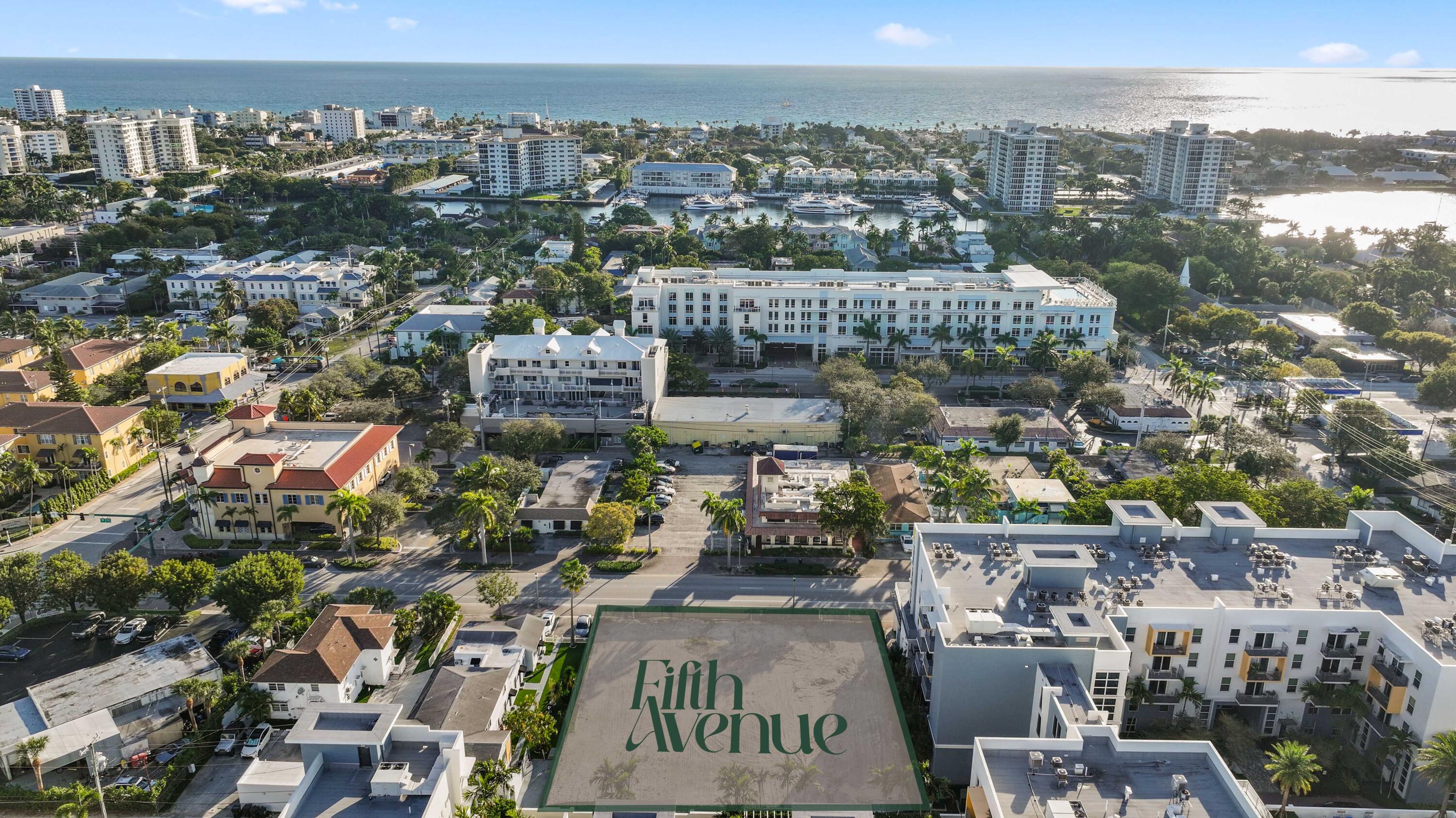 Aerial view of Fifth Avenue residences, a marina, and the Atlantic coastline.