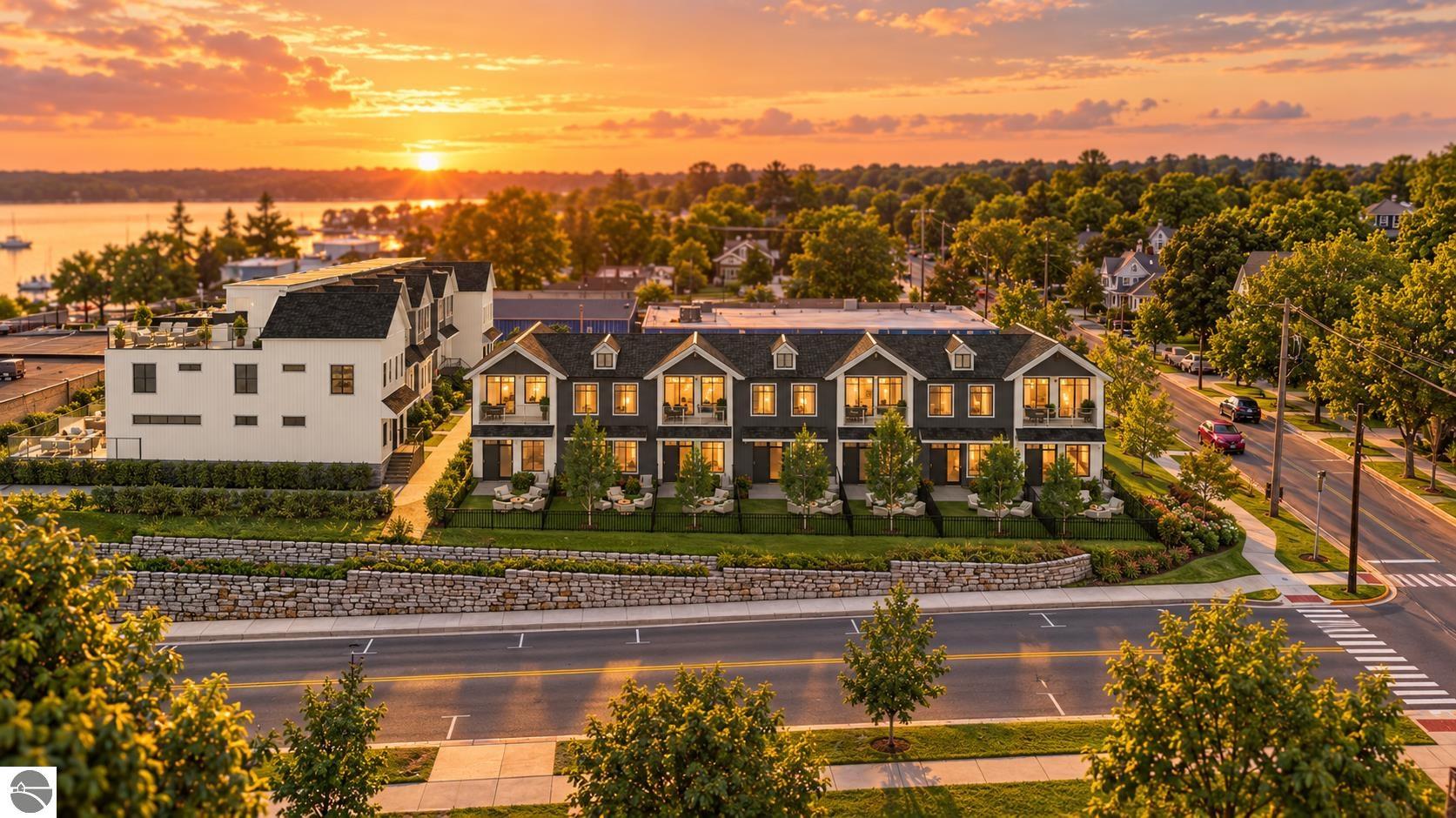 Townhomes overlooking a lake at sunset, with landscaped patios and a tree-lined shoreline.