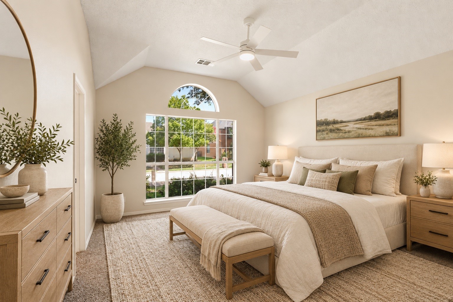 Staged bedroom with a king-size bed beneath a vaulted ceiling and an arched transom window.