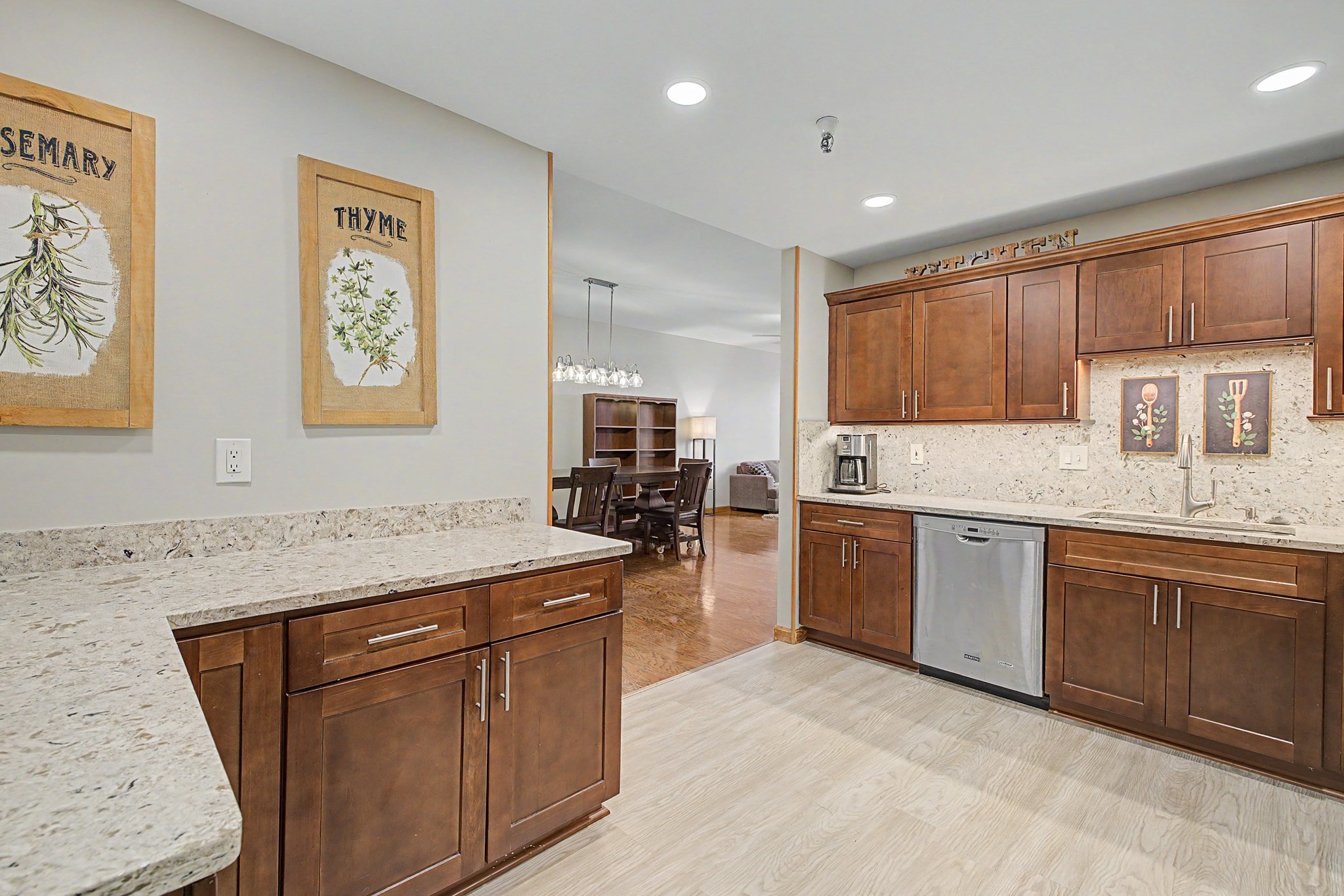 Kitchen with dark wood cabinetry, stone counters, a large island, and an adjoining dining area.