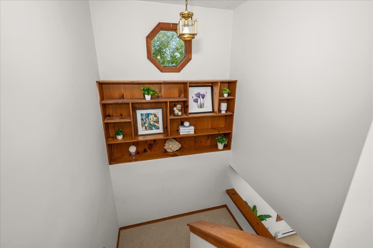 Staircase landing with built-in wooden shelves and an octagonal window.