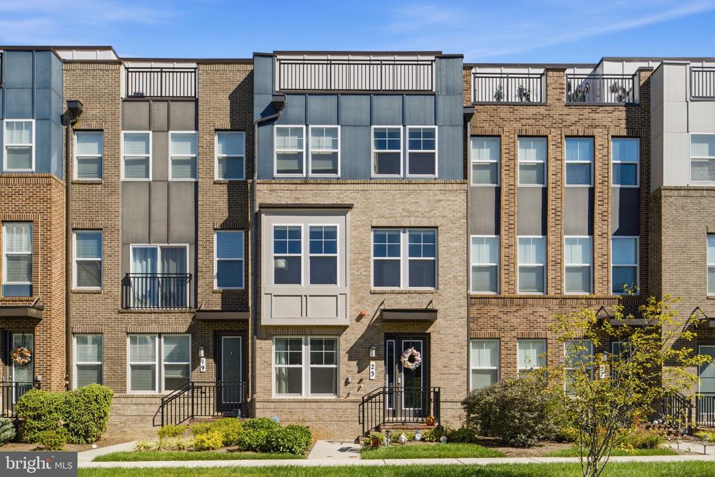 Modern brick townhouses with tall windows, rooftop terraces, and landscaped front walks.