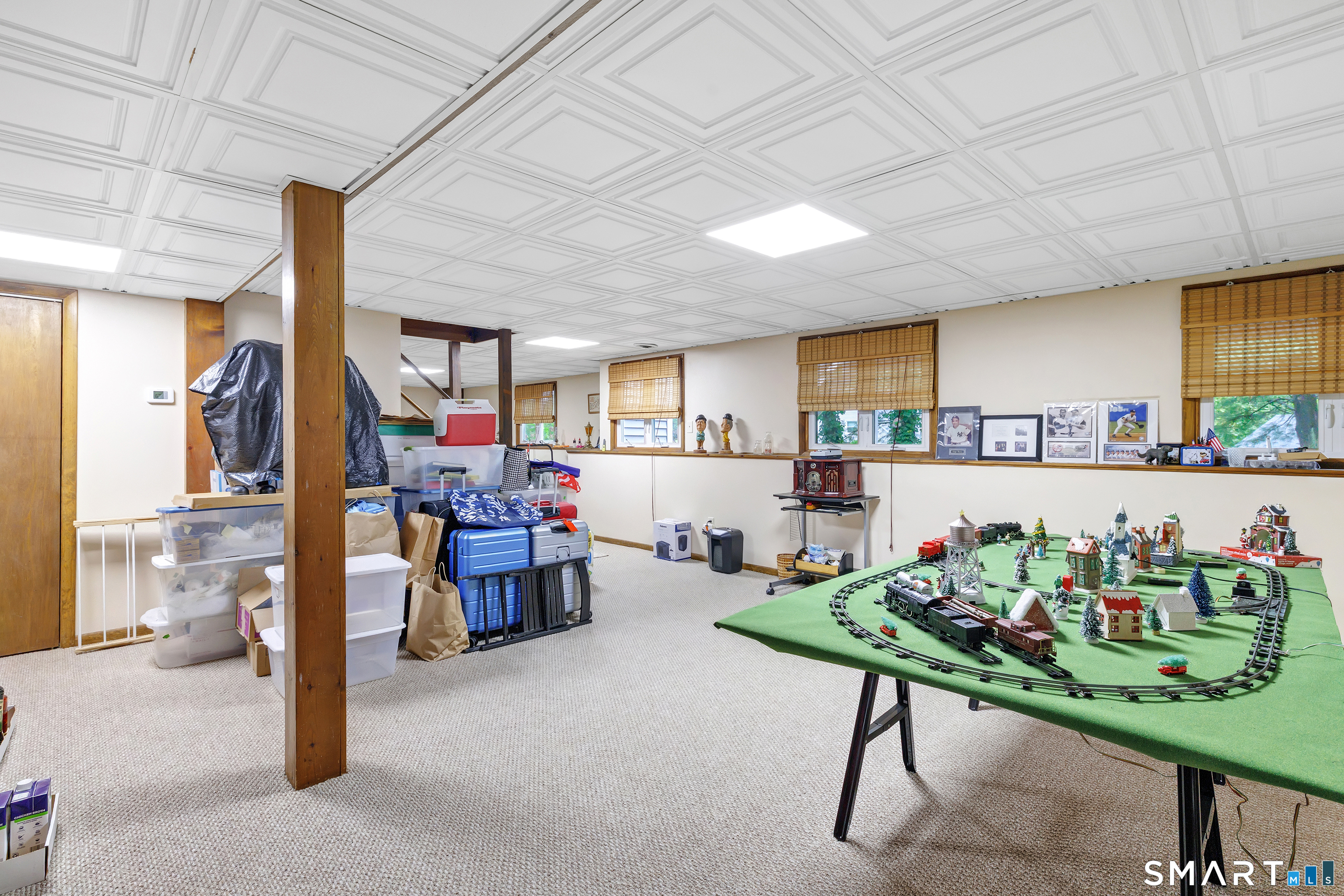 Basement room with a large model train layout and stored belongings.