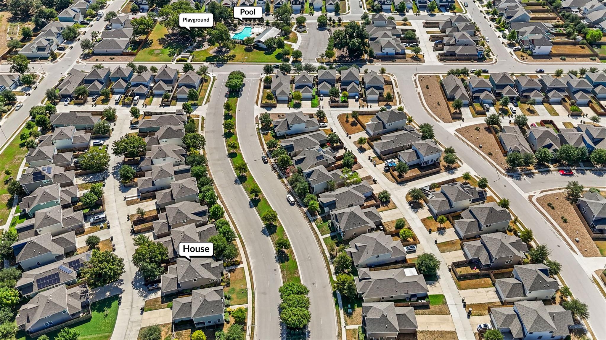 Aerial neighborhood view showing the listed house, community pool, and playground.