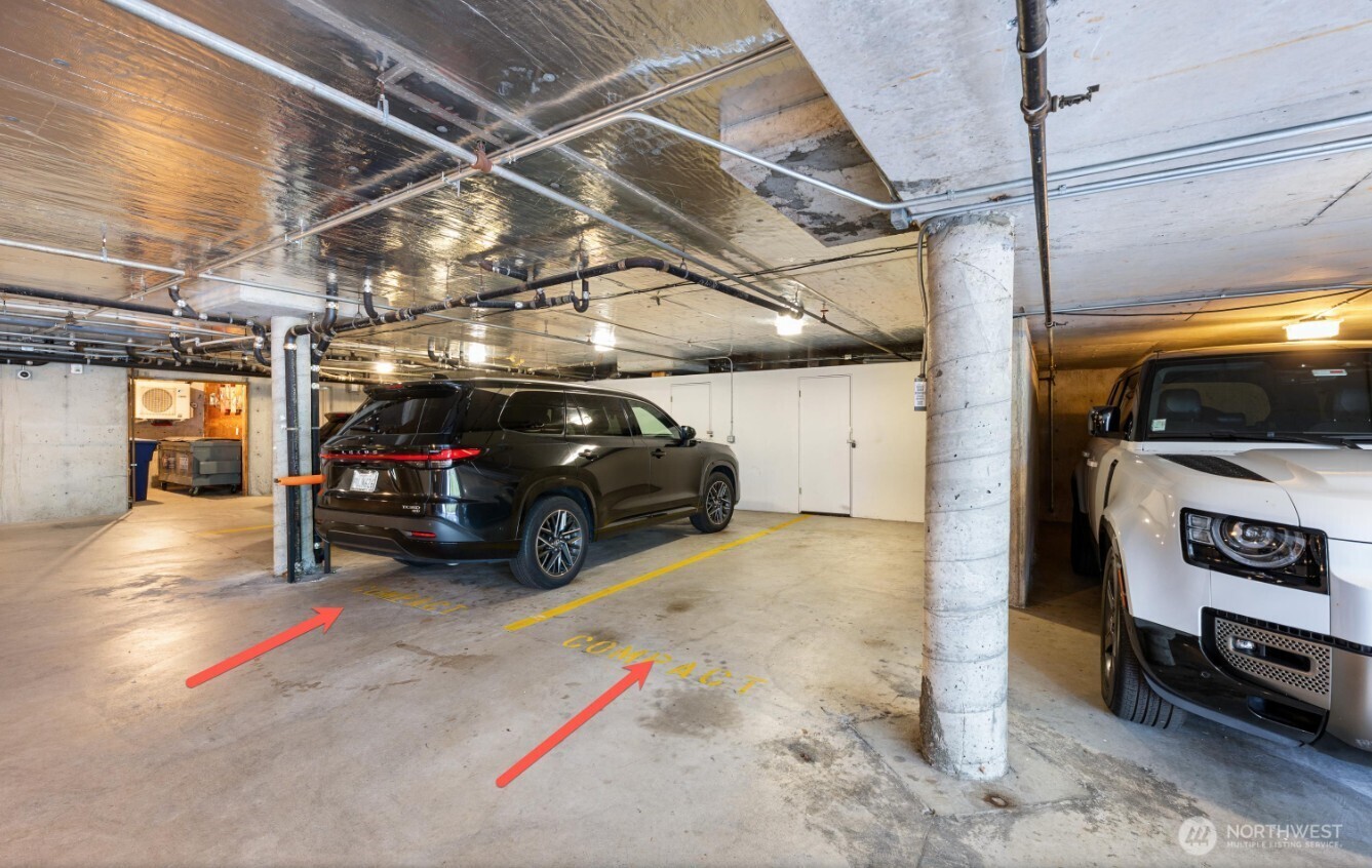 Parking garage with marked spaces, two vehicles, and red arrows pointing to the parking areas.
