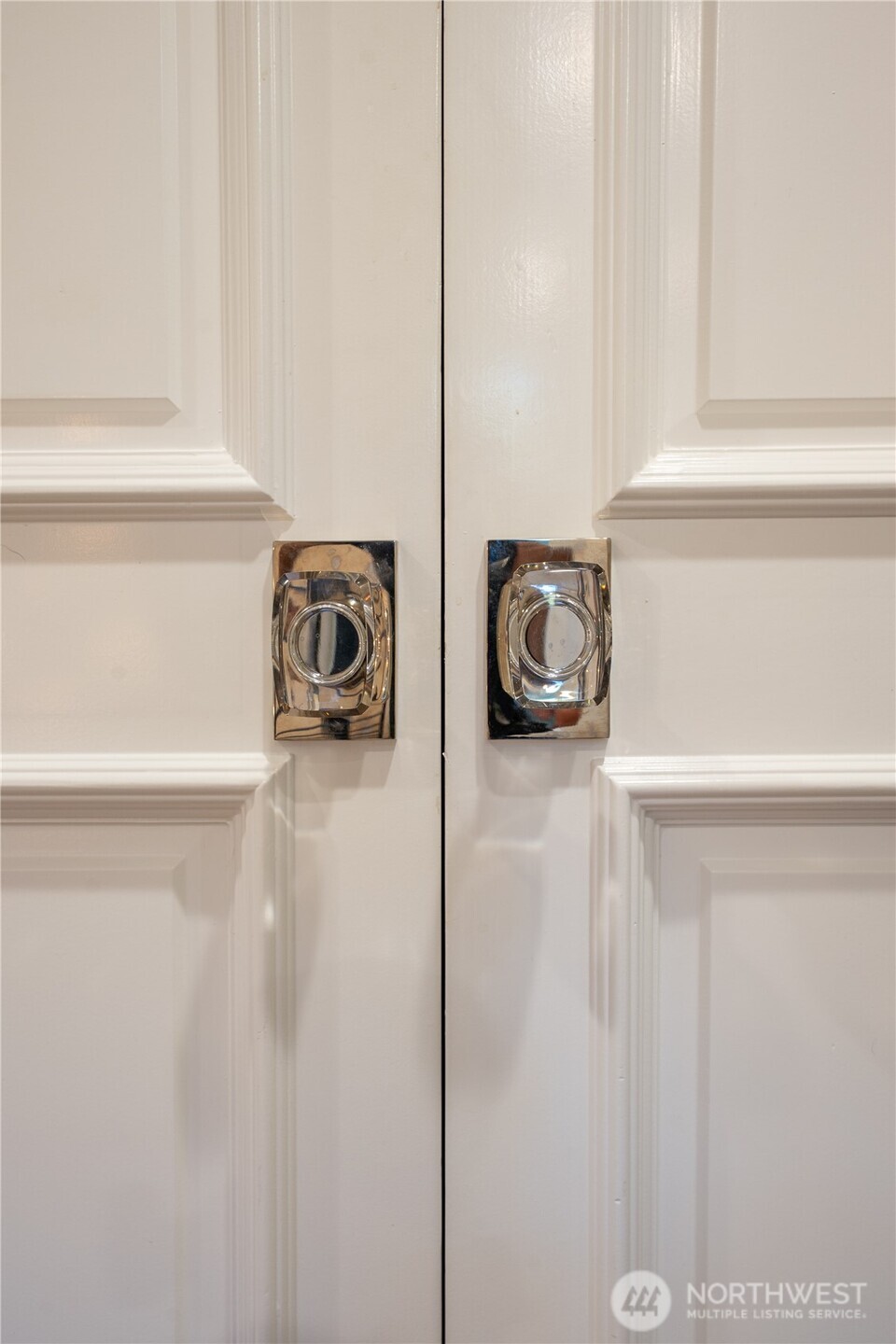 White paneled double doors with matching crystal knobs.