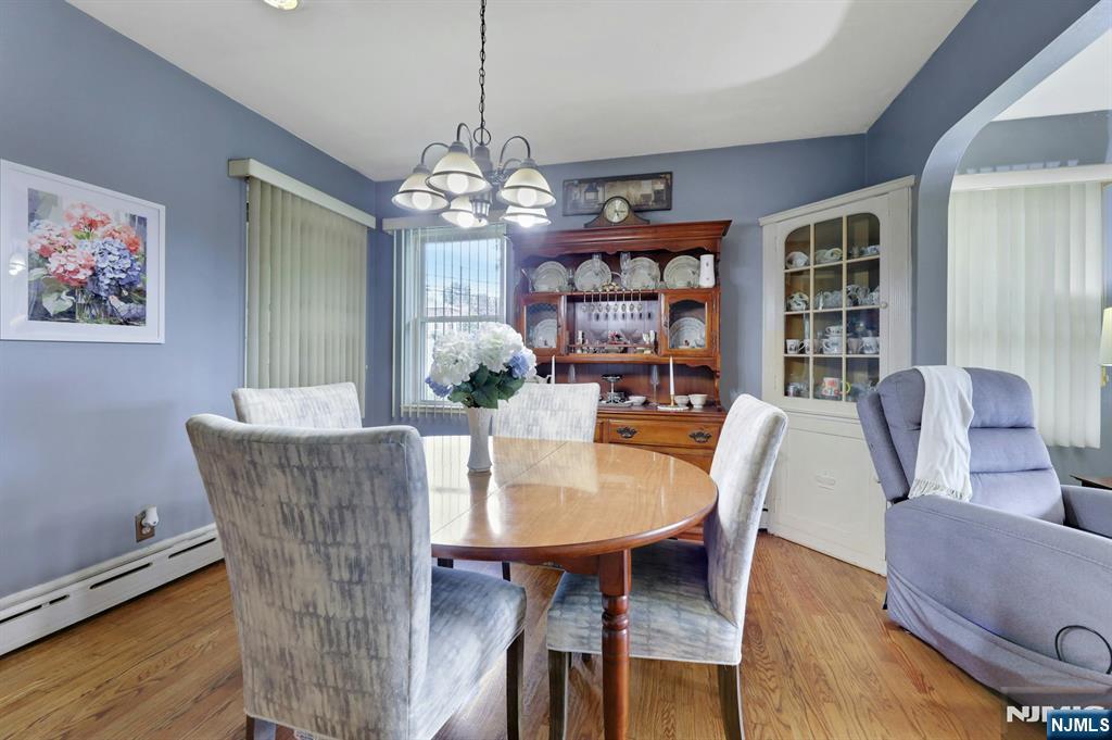 Dining room with a round wooden table, china hutch, and blue-gray walls.