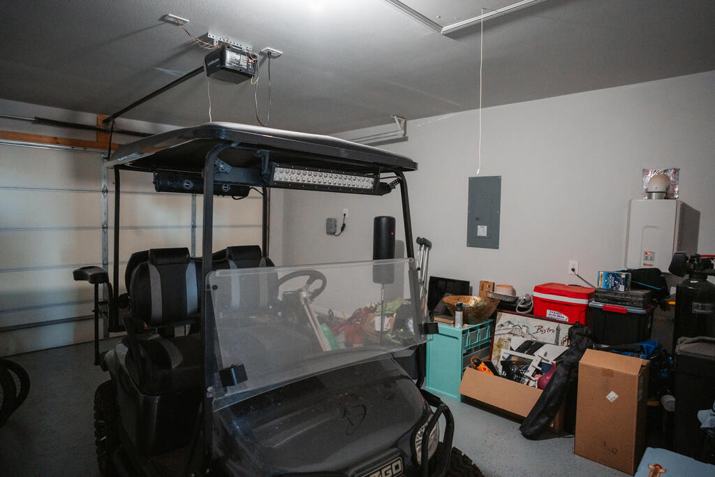 Garage with a large golf cart parked beside storage bins and boxes.