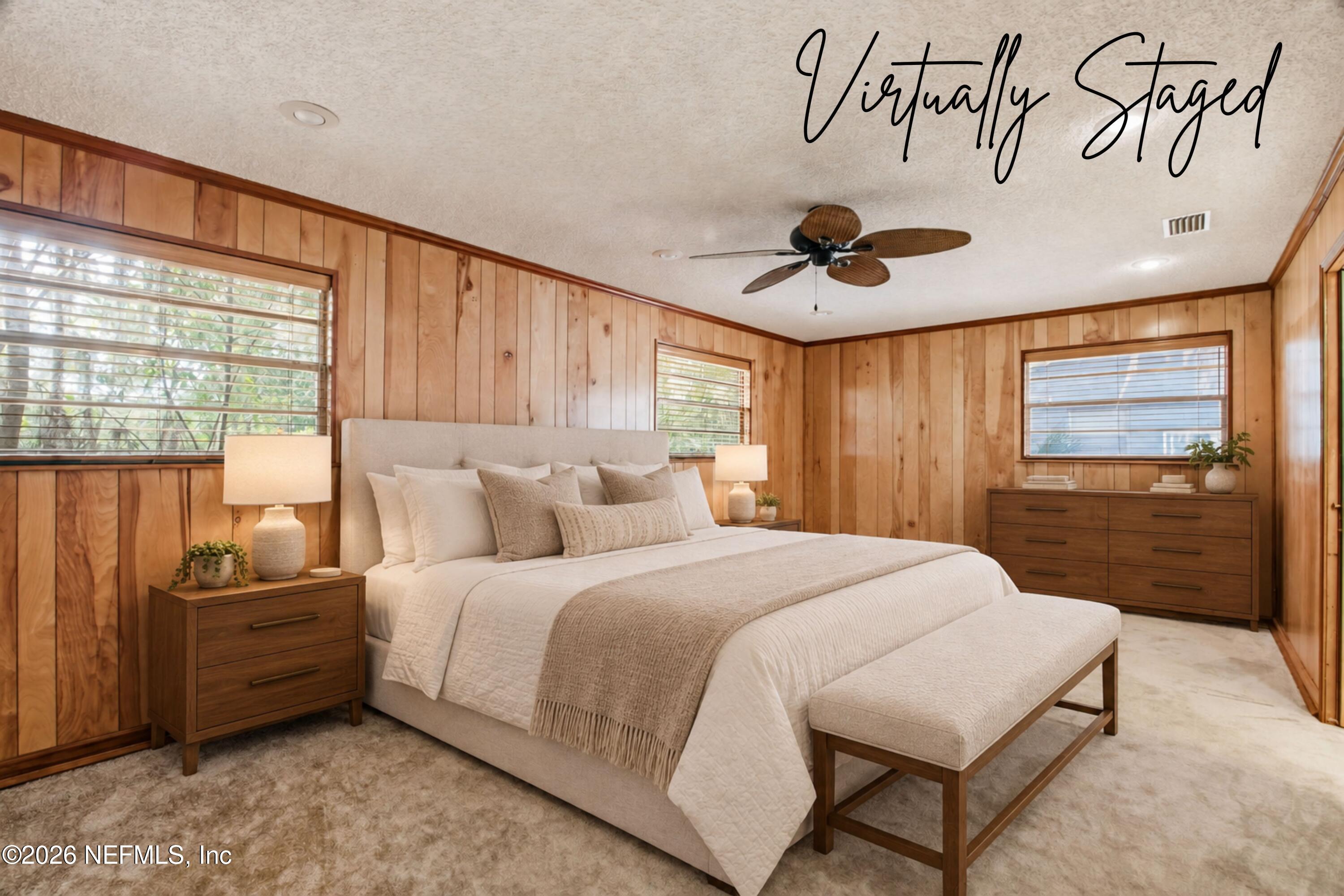 Virtually staged bedroom with a cream bed and bench against warm wood-paneled walls.
