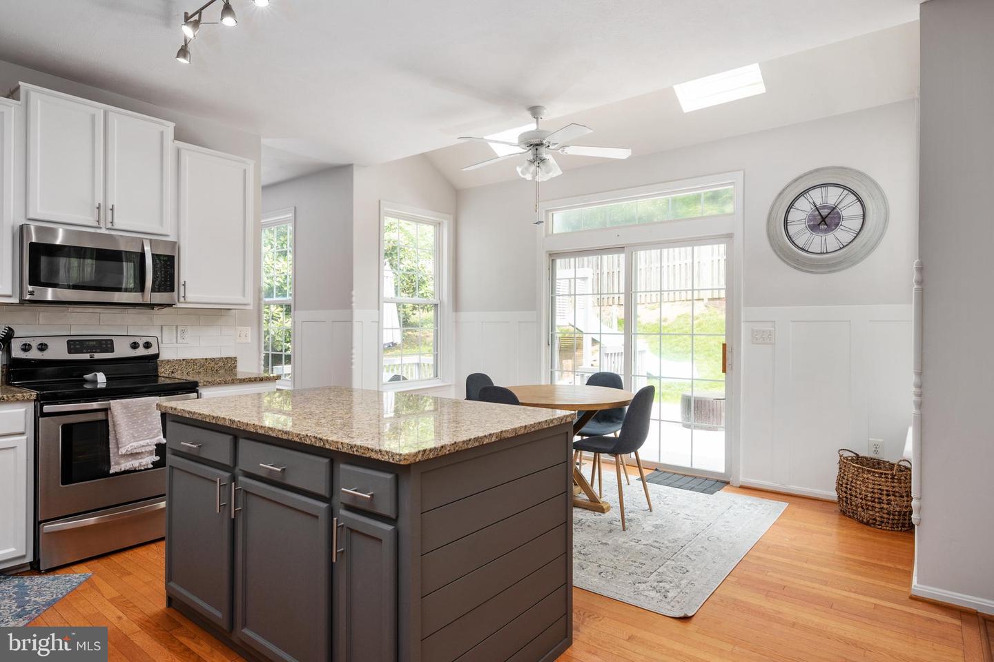 Kitchen with a granite-topped island and dining area beside sliding glass doors.