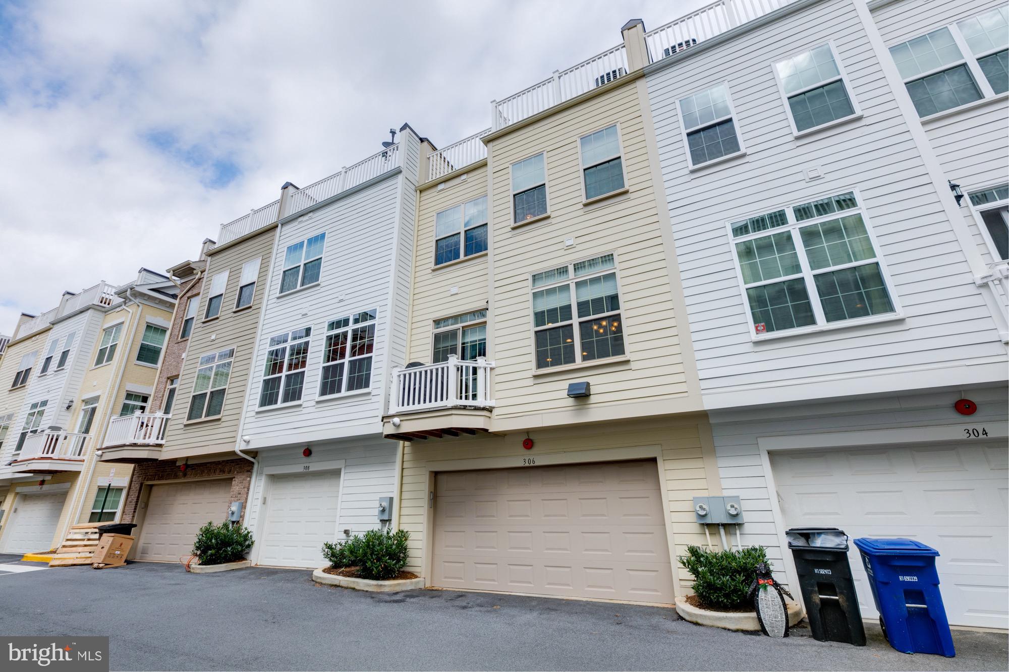 Beige townhome at 306 N George Mason Dr with a garage, balcony, and rooftop deck.