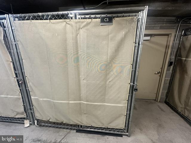 Metal storage cage labeled C5 beside a service door in a concrete hallway.