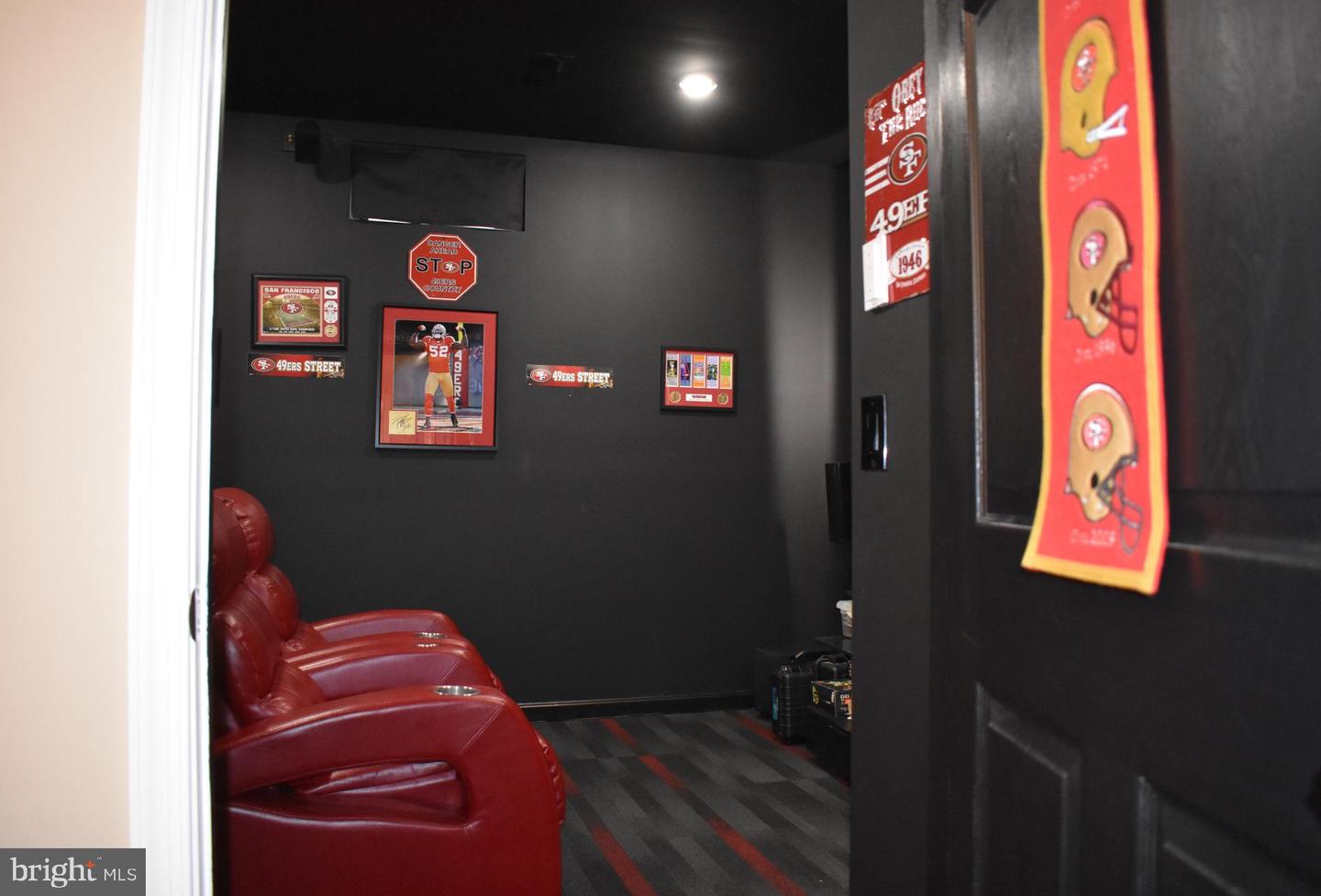 Home theater with red leather reclining seats and San Francisco 49ers memorabilia.