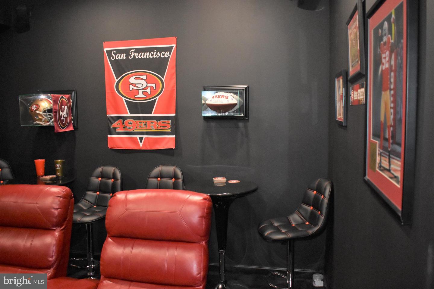 49ers-themed recreation room with red leather recliners and framed football memorabilia.