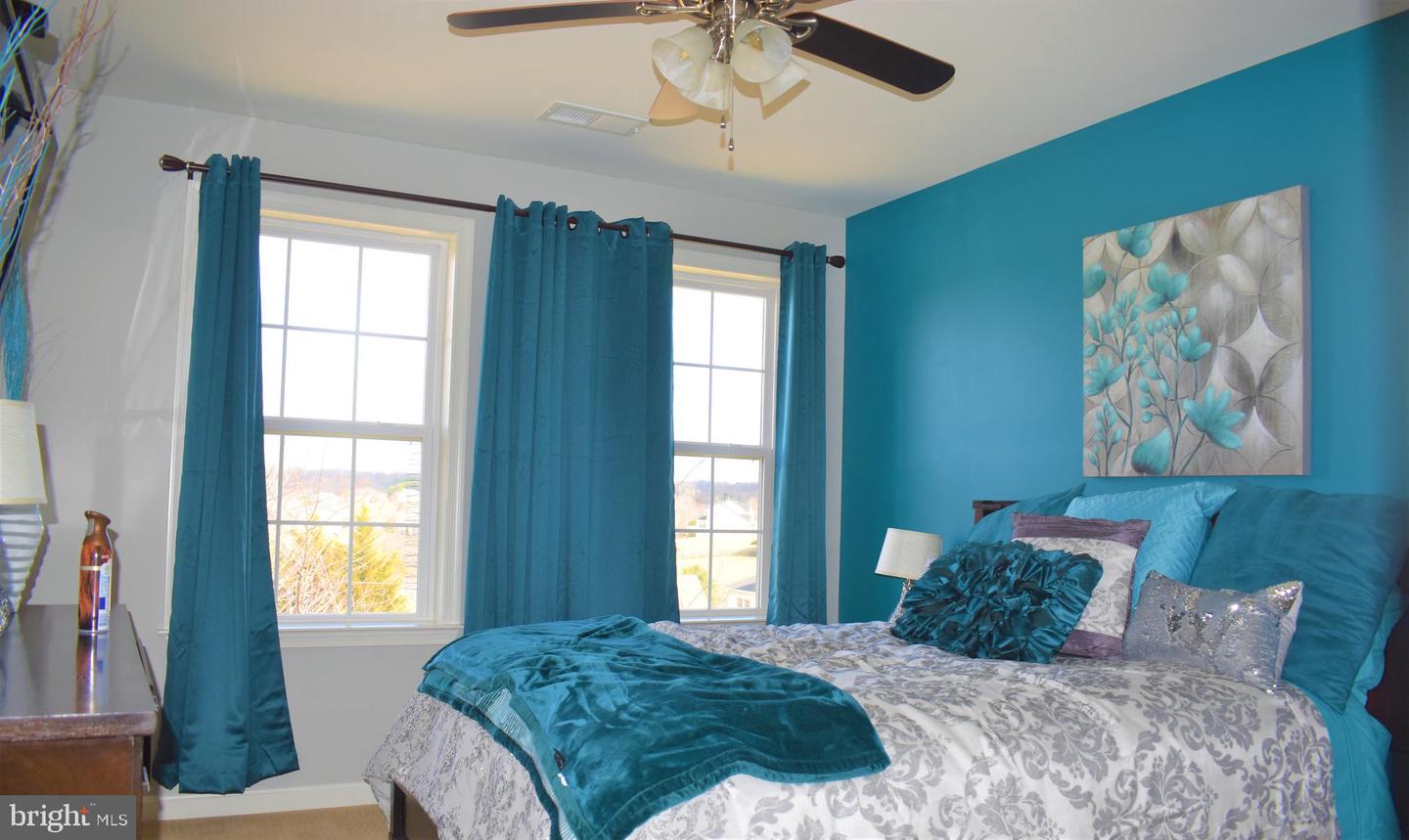 Bedroom with teal bedding, matching curtains, and a turquoise accent wall.