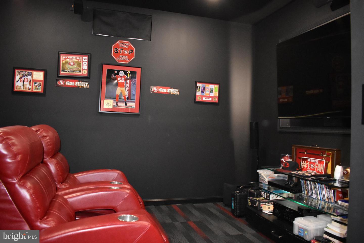 Home theater with red leather recliners, a large TV, and San Francisco 49ers memorabilia.