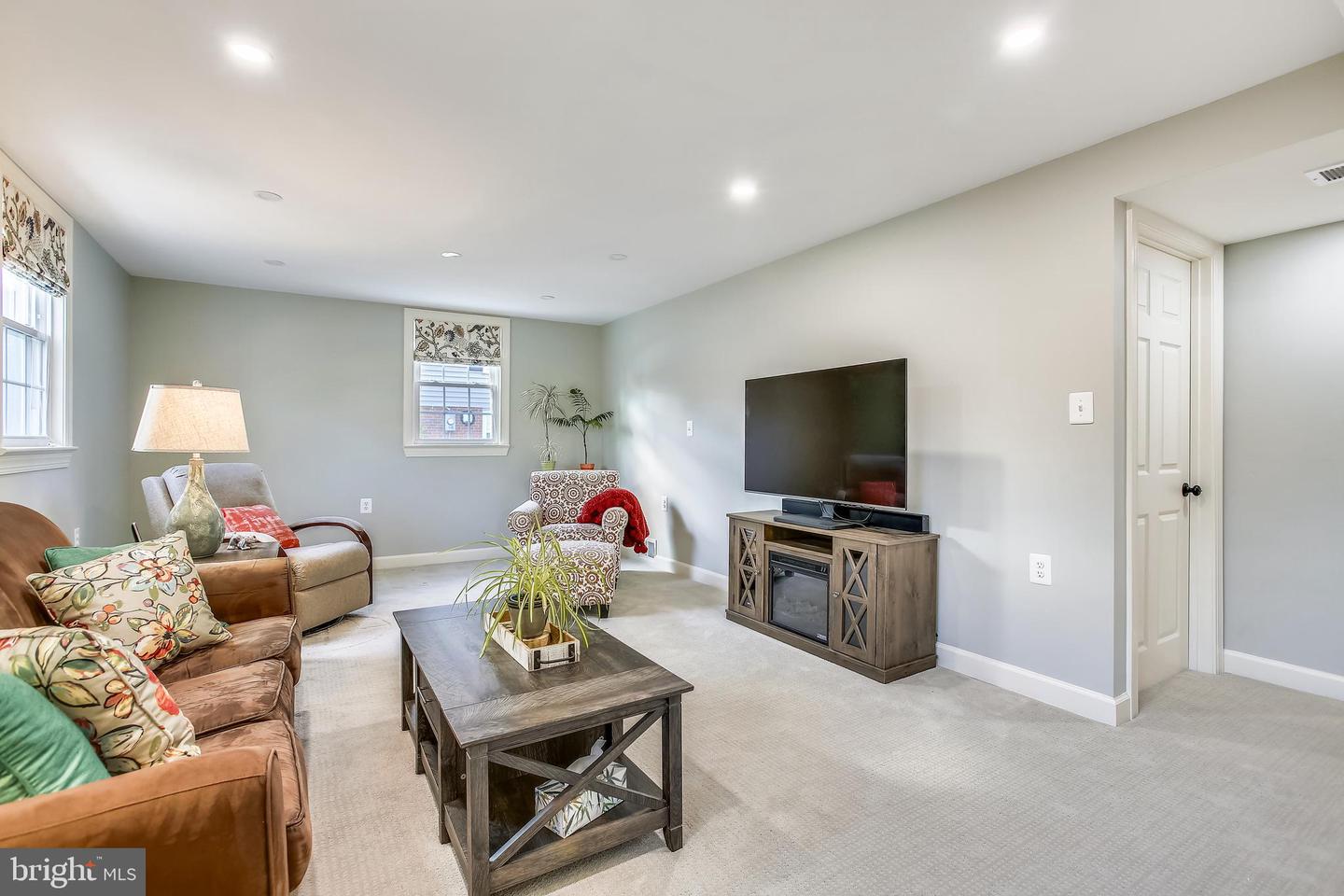 Living room with brown sofas, a dark wood coffee table, and a television console.