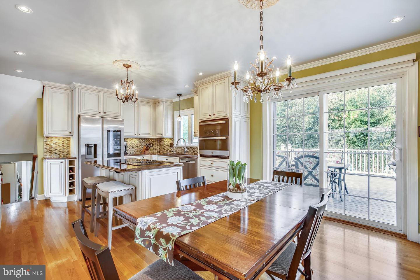 Kitchen and dining area with white cabinetry, a central island, and sliding doors to a deck.