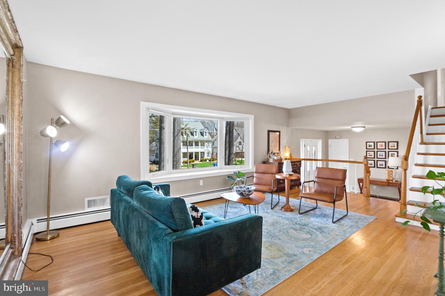 Living room with a blue sofa, leather chairs, hardwood floors, and a large picture window.