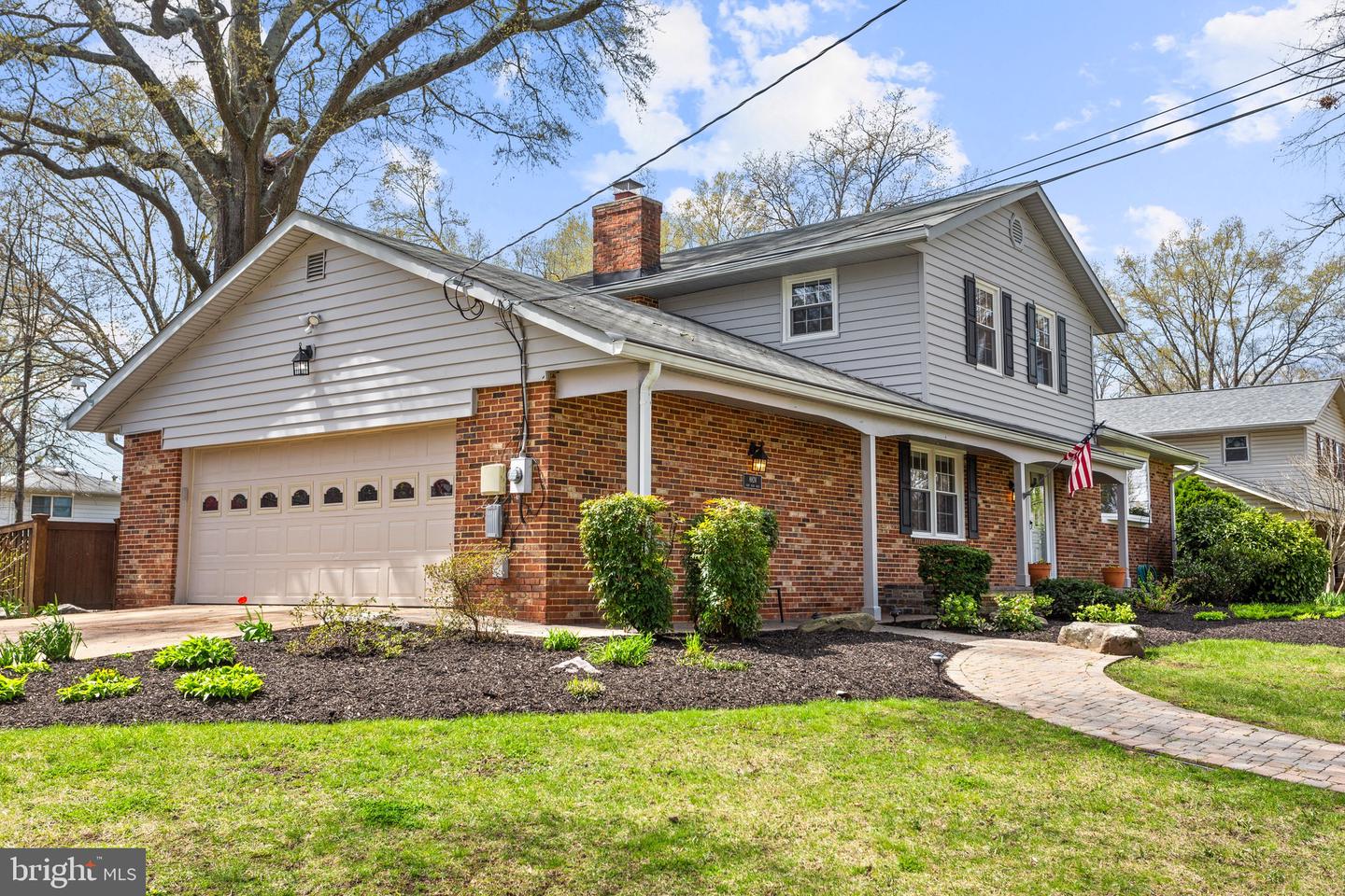 Two-story brick-and-siding house with an attached garage and curved front walkway.