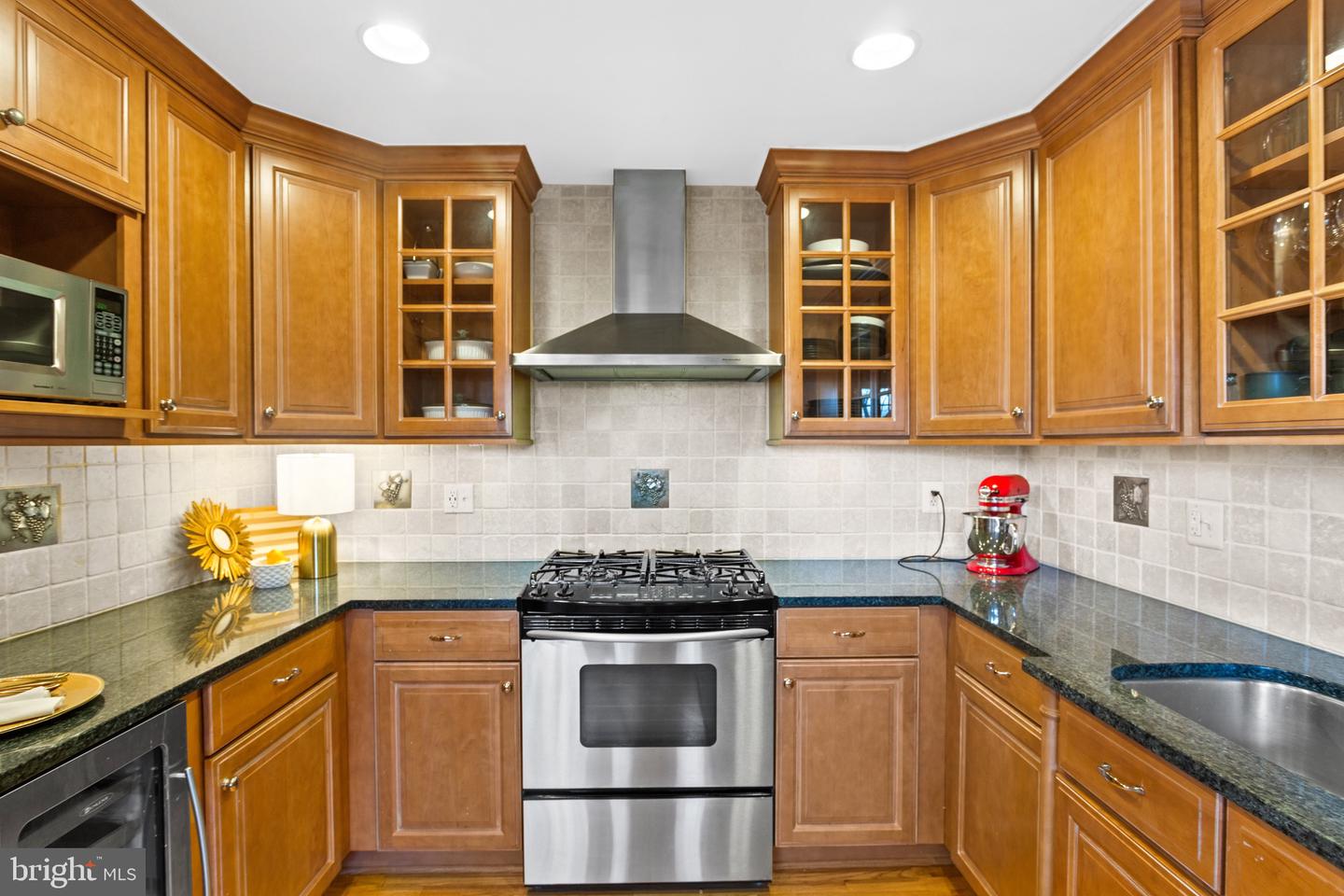 Kitchen with wood cabinets, granite counters, and a stainless steel gas range.