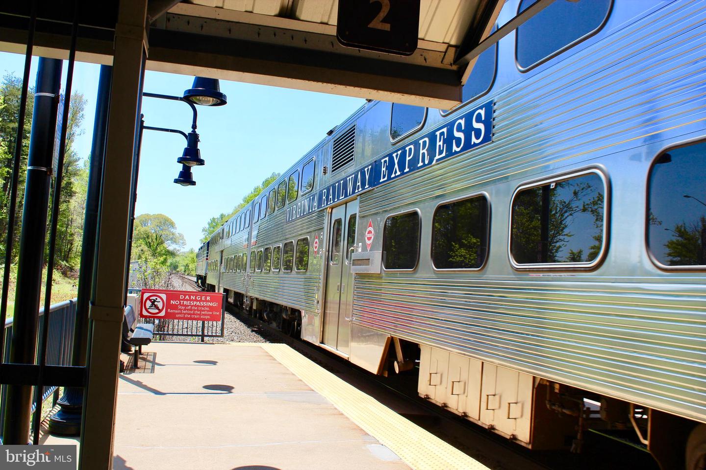 Virginia Railway Express train stopped beside a station platform.