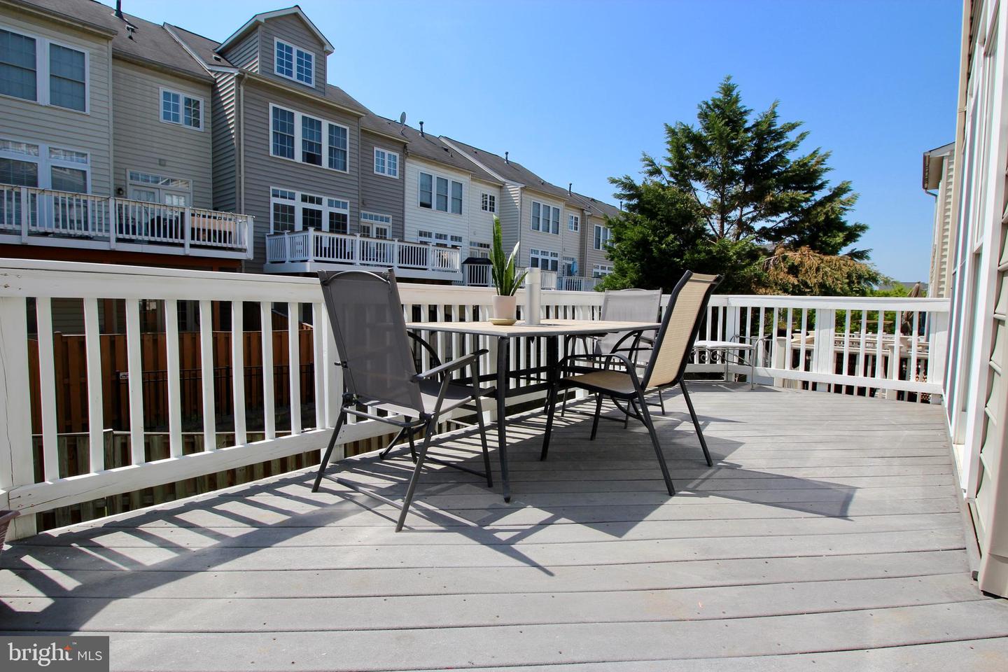 Furnished deck with an outdoor dining set and views of neighboring townhouses.