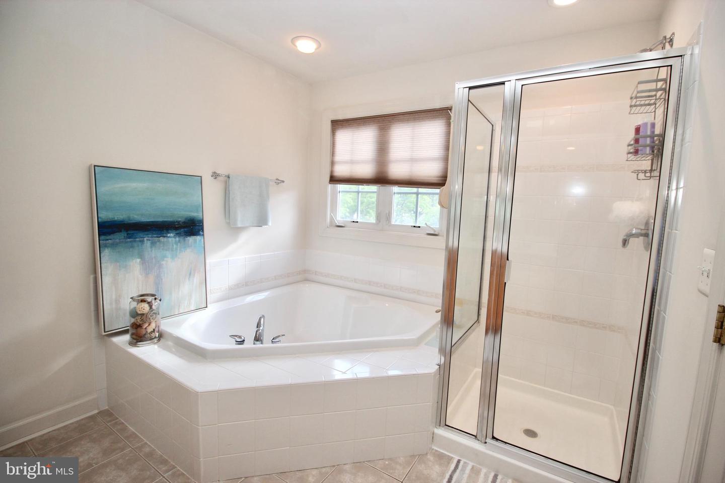 Bathroom with a corner soaking tub and a separate glass-enclosed shower.
