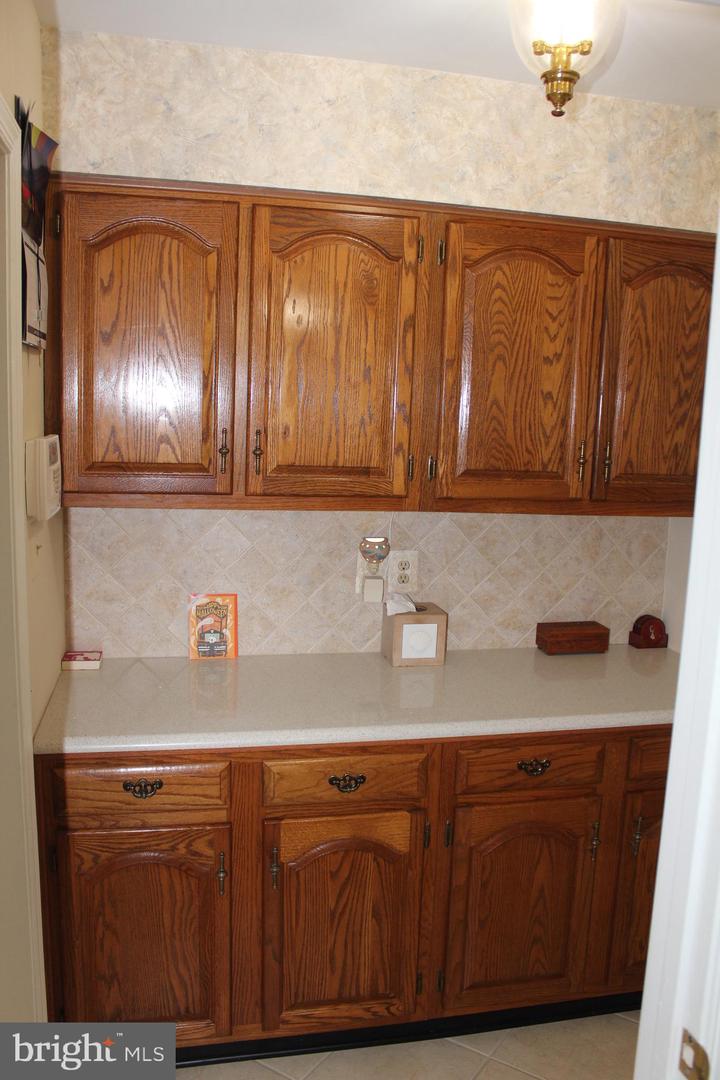 Kitchen with oak cabinets, decorative hardware, and a light countertop.