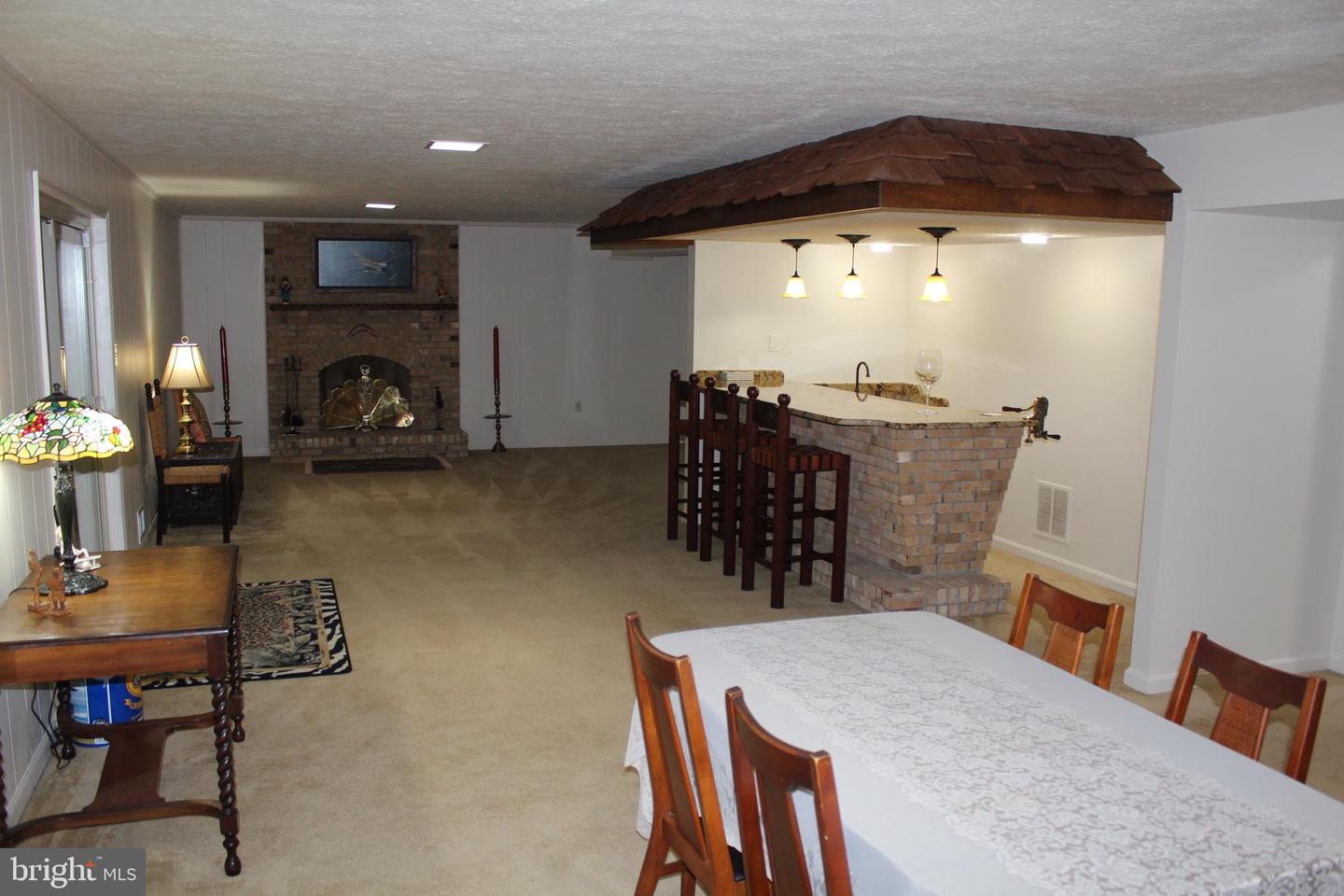 Dining and living area with a brick wet bar, wood canopy, and fireplace.