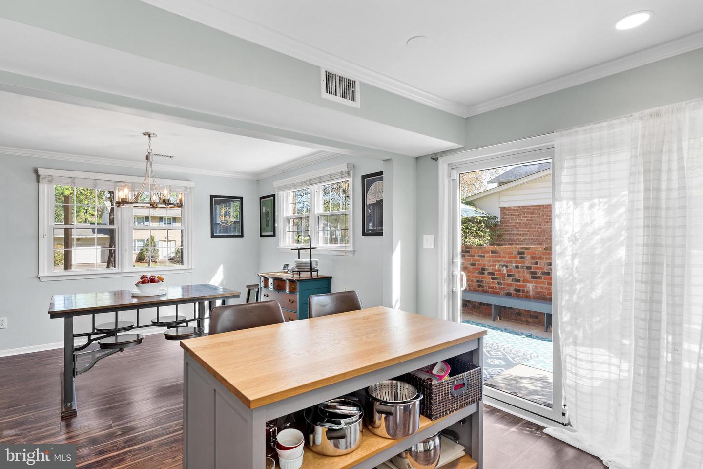 Kitchen and dining area with a wood-topped island and sliding doors to a brick patio.