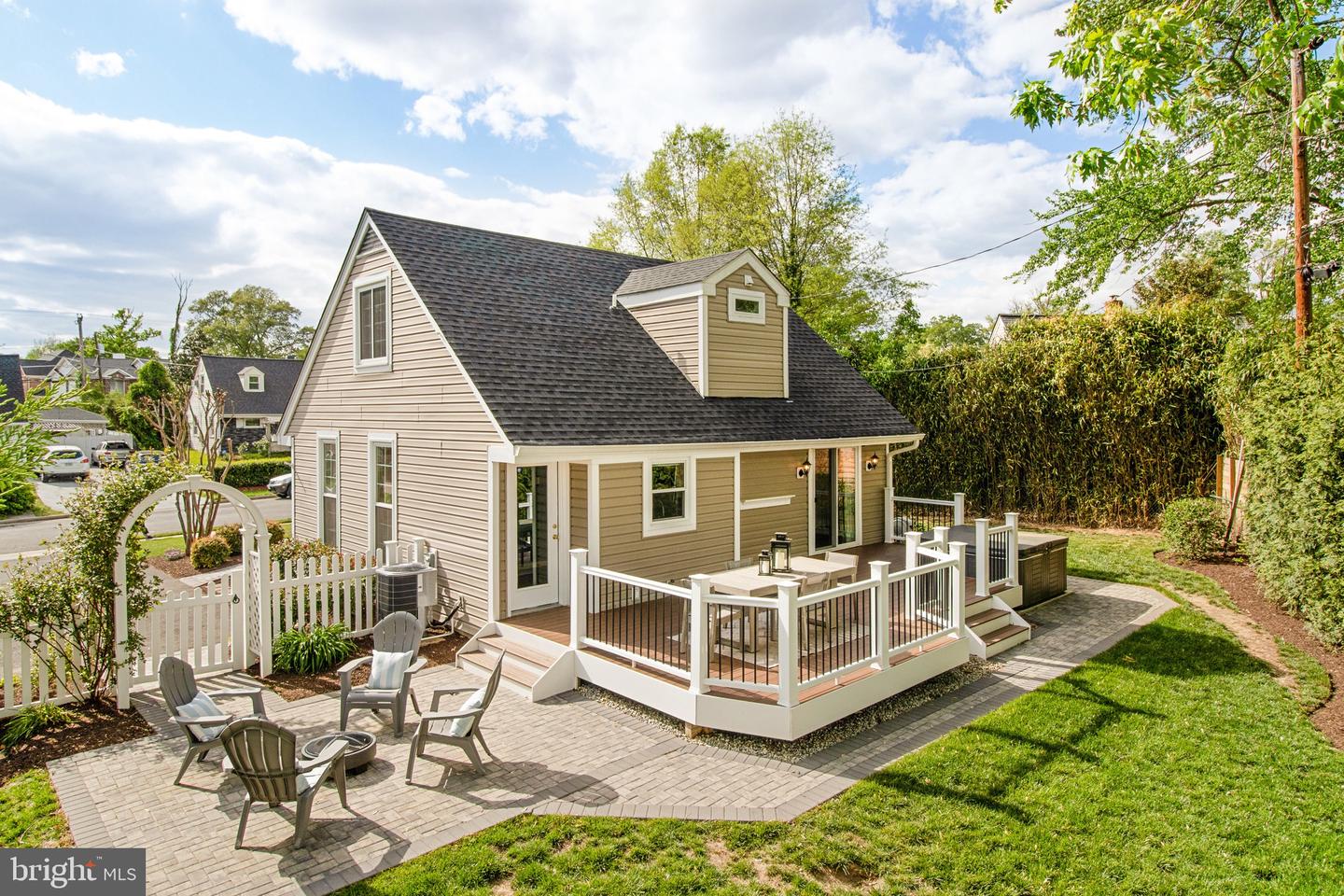 Home with a raised deck and furnished patio, viewed from above the backyard.