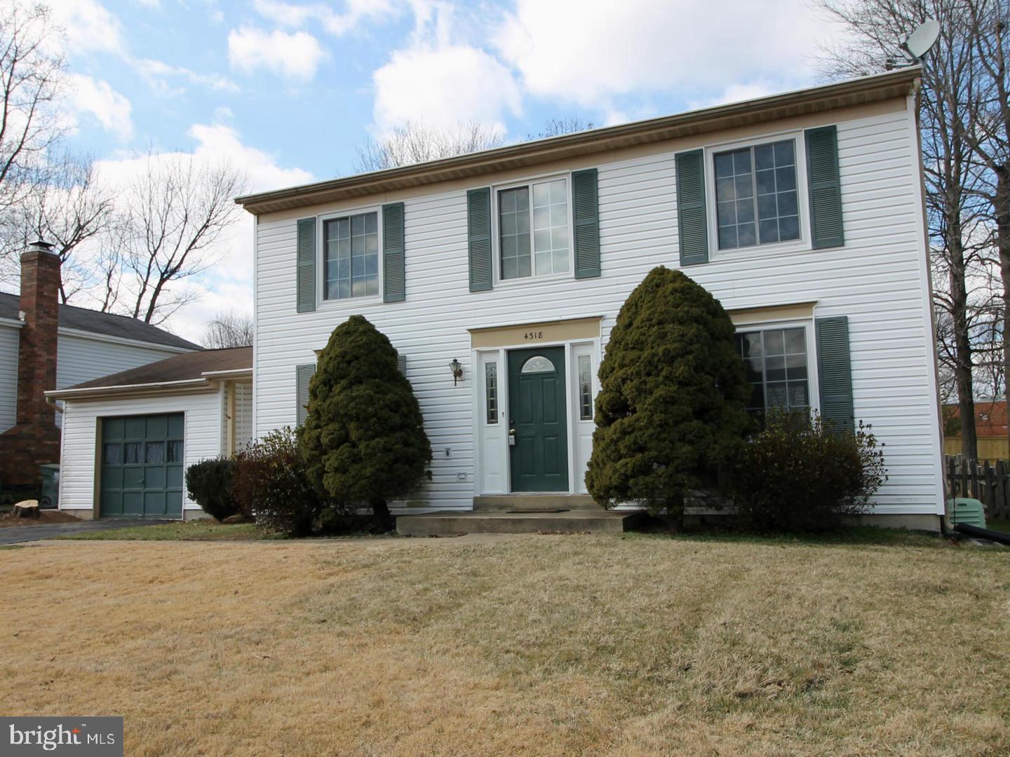 Two-story white house with green shutters, a green front door, and an attached garage.